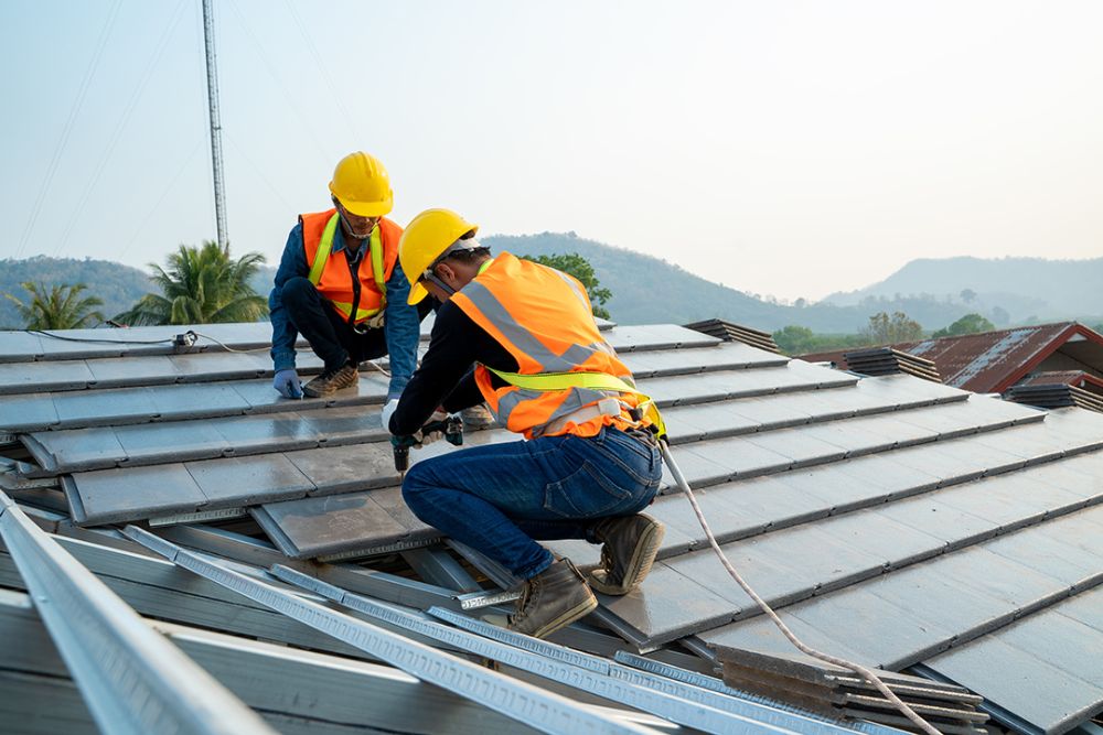 Two men engaged in solar panel installation on a roof, highlighting our roofing expertise in Akron, OH.